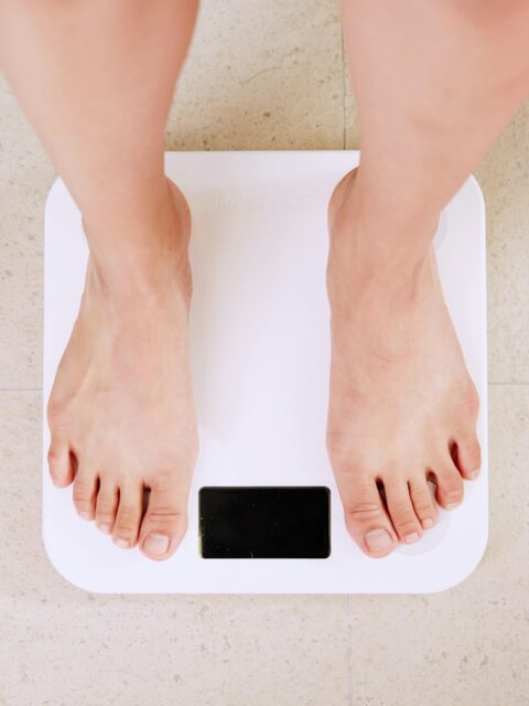 person standing on white digital bathroom scale